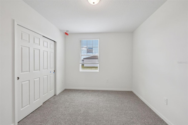 unfurnished bedroom featuring carpet and baseboards