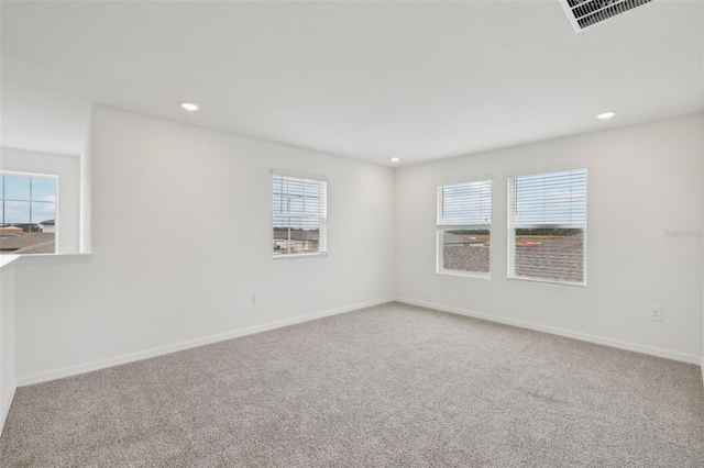 unfurnished room with carpet, visible vents, baseboards, and recessed lighting