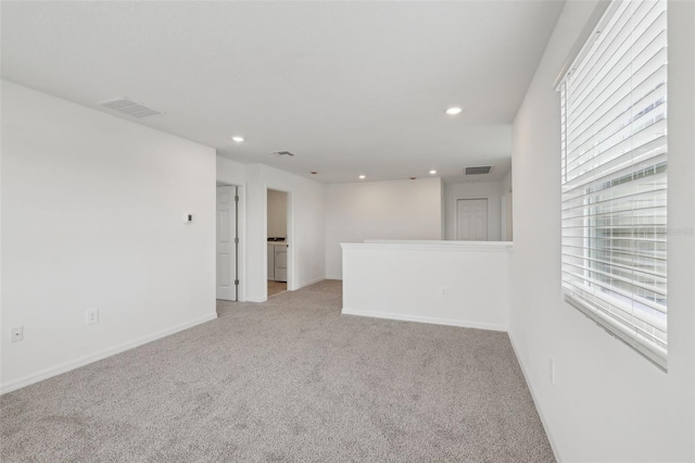 unfurnished room with light carpet, visible vents, baseboards, and recessed lighting