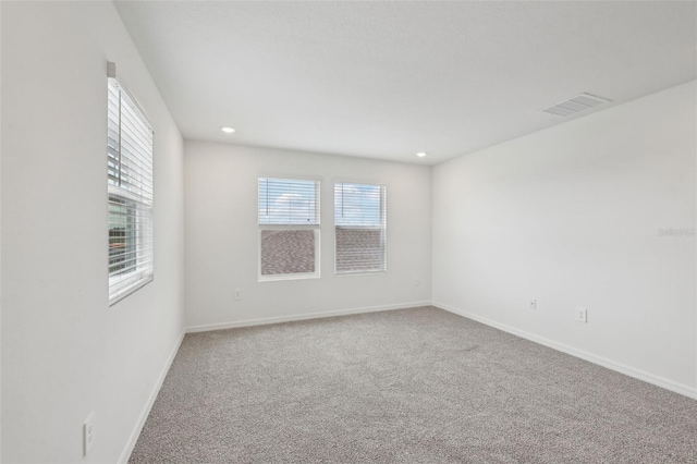 unfurnished room featuring carpet, visible vents, baseboards, and recessed lighting