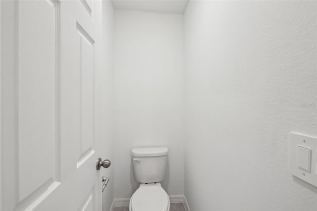 bathroom with toilet and baseboards