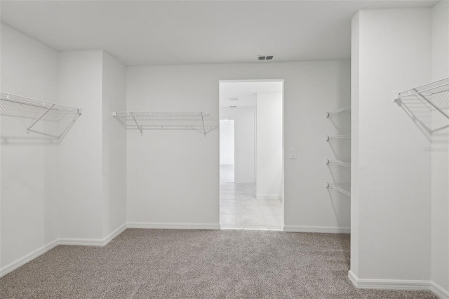 spacious closet featuring visible vents and light colored carpet