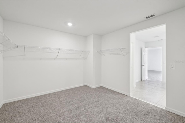 walk in closet featuring light carpet and visible vents