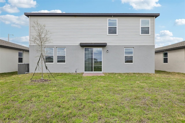 back of property featuring a lawn, cooling unit, and stucco siding