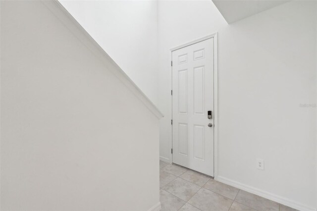 interior space with baseboards and light tile patterned floors