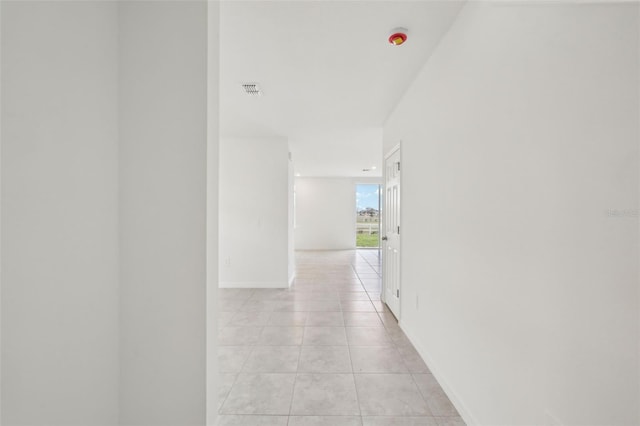 hall with light tile patterned floors and baseboards