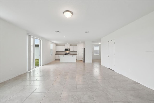 unfurnished living room featuring recessed lighting, visible vents, and light tile patterned flooring