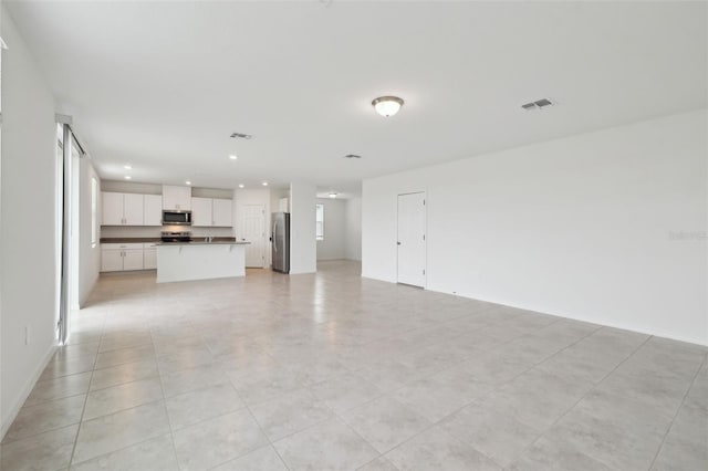 unfurnished living room with visible vents and recessed lighting