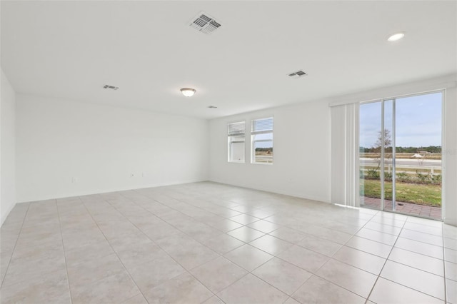 empty room with light tile patterned floors, visible vents, and recessed lighting