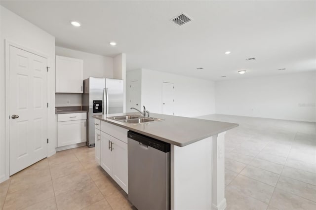 kitchen with a center island with sink, visible vents, stainless steel appliances, white cabinetry, and a sink