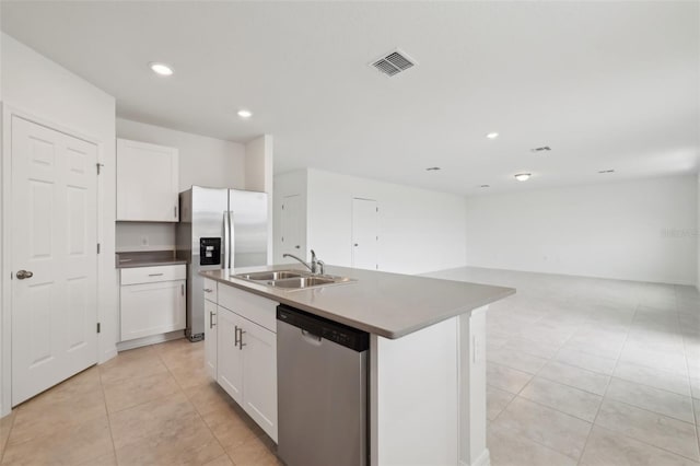 kitchen with a center island with sink, visible vents, appliances with stainless steel finishes, white cabinetry, and a sink