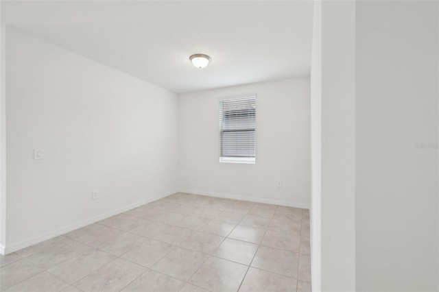 unfurnished room featuring baseboards and light tile patterned floors