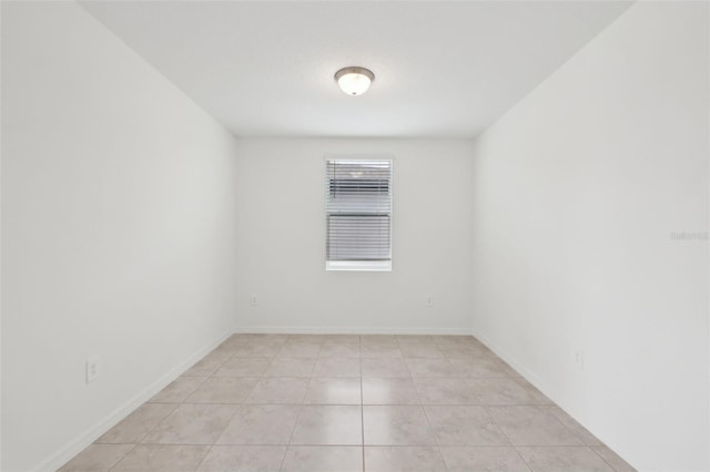 empty room featuring light tile patterned floors and baseboards