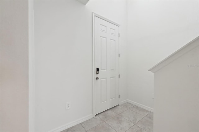 foyer entrance with light tile patterned flooring and baseboards