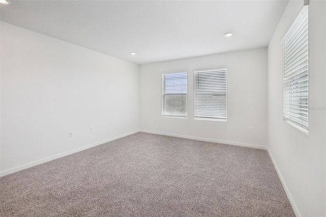 carpeted empty room featuring plenty of natural light, baseboards, and recessed lighting