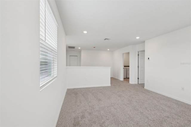 carpeted empty room with baseboards, visible vents, washer and clothes dryer, and recessed lighting