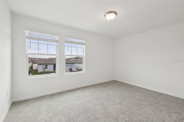 carpeted spare room with baseboards