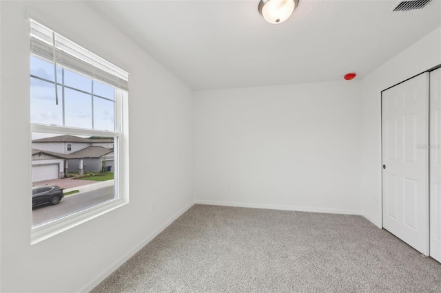 unfurnished bedroom featuring carpet, visible vents, and baseboards