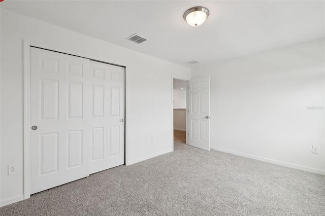 unfurnished bedroom featuring carpet, visible vents, and baseboards