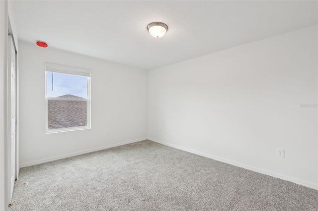 carpeted spare room with baseboards