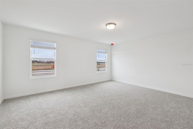 carpeted empty room with baseboards