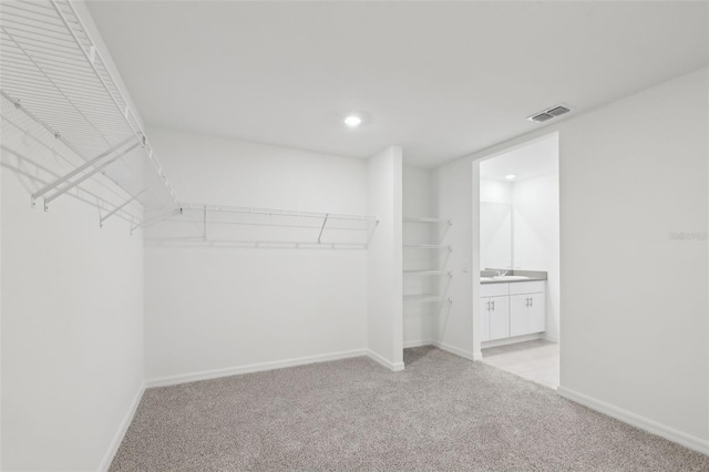 walk in closet with visible vents and light carpet