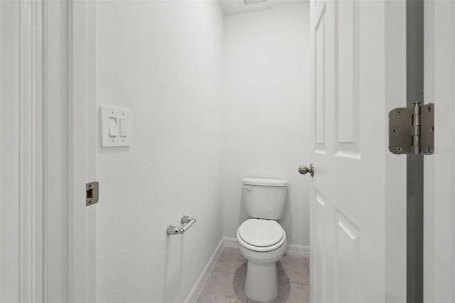 bathroom with toilet, baseboards, and tile patterned floors