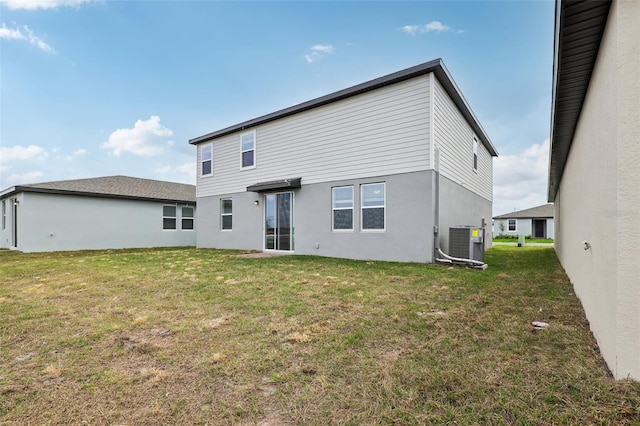 back of house featuring cooling unit, a lawn, and stucco siding