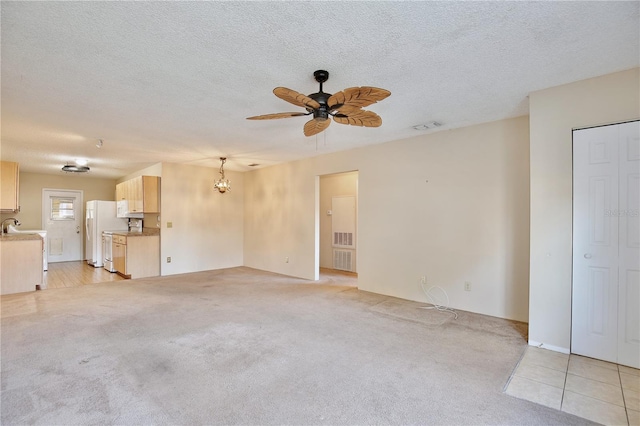 unfurnished living room with ceiling fan with notable chandelier, a textured ceiling, and light carpet