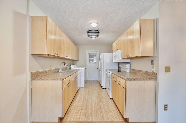 kitchen with white appliances, a textured ceiling, washing machine and dryer, light brown cabinets, and sink