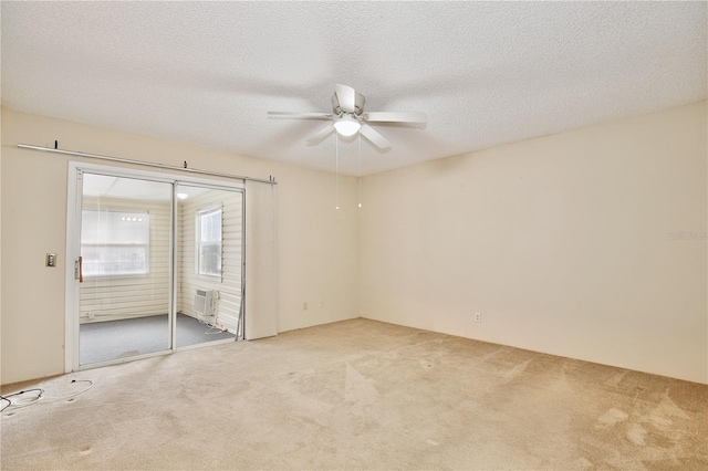 carpeted spare room with ceiling fan and a textured ceiling