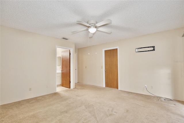 carpeted empty room with ceiling fan and a textured ceiling