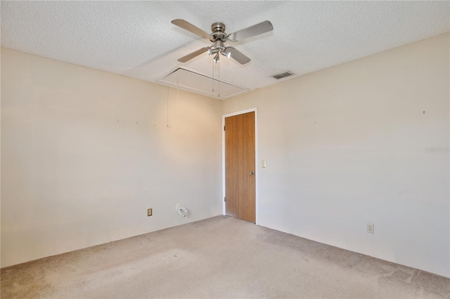 empty room featuring ceiling fan, carpet, and a textured ceiling