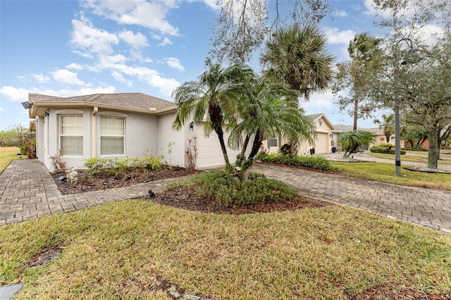 view of front of house featuring a garage and a front lawn