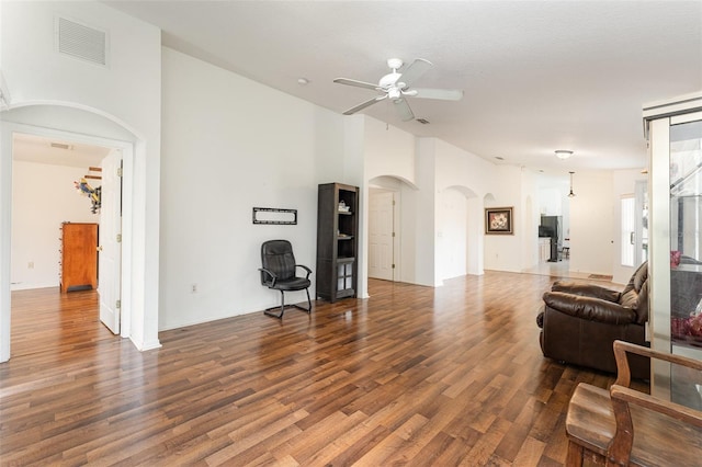 living room with dark wood-type flooring and ceiling fan