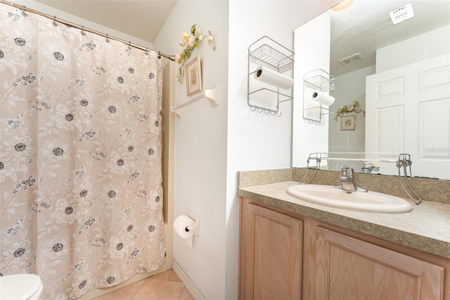 bathroom featuring tile patterned flooring, vanity, and toilet