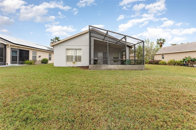 rear view of house with a yard and glass enclosure