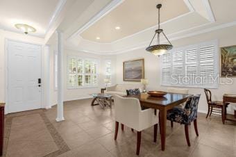 tiled dining area with a tray ceiling, recessed lighting, and crown molding