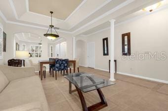 living room with arched walkways, crown molding, a raised ceiling, and baseboards