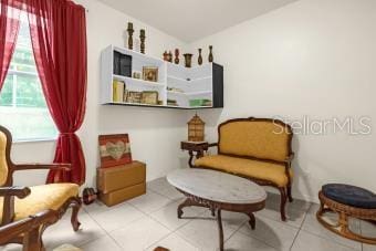 sitting room with tile patterned floors and lofted ceiling