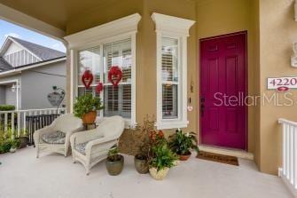 entrance to property featuring stucco siding and covered porch