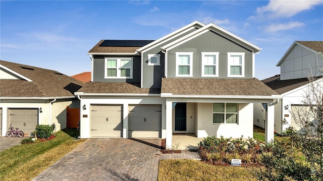 view of front of house with a garage, solar panels, and a porch