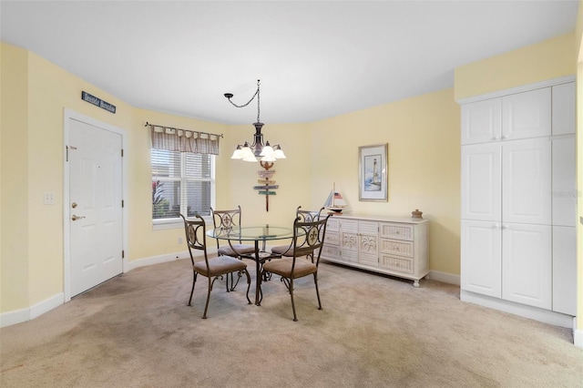 dining area featuring light carpet and a chandelier