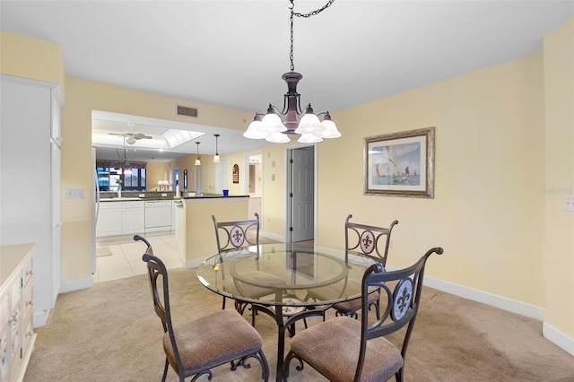 dining space with light carpet and a chandelier