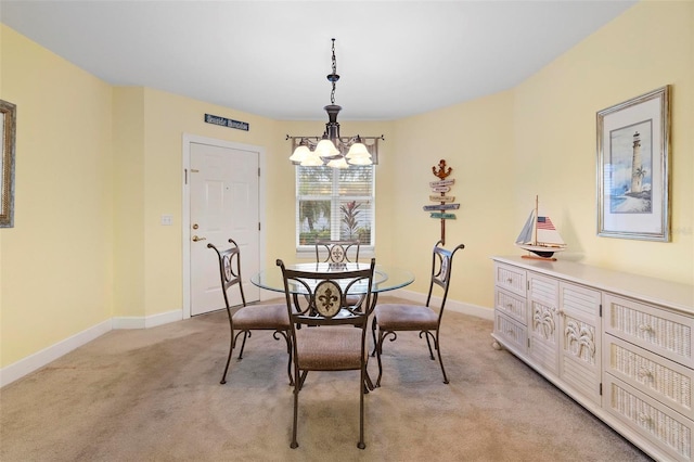 dining space with light carpet and a chandelier