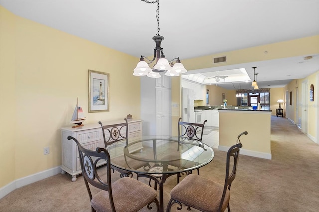 dining area featuring a chandelier and light colored carpet