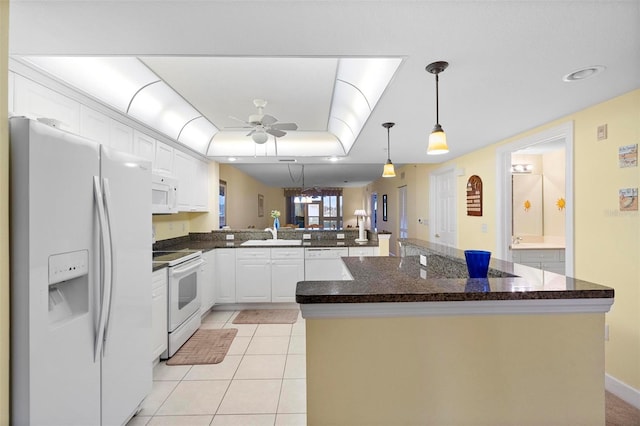 kitchen with white appliances, white cabinets, a center island, and kitchen peninsula