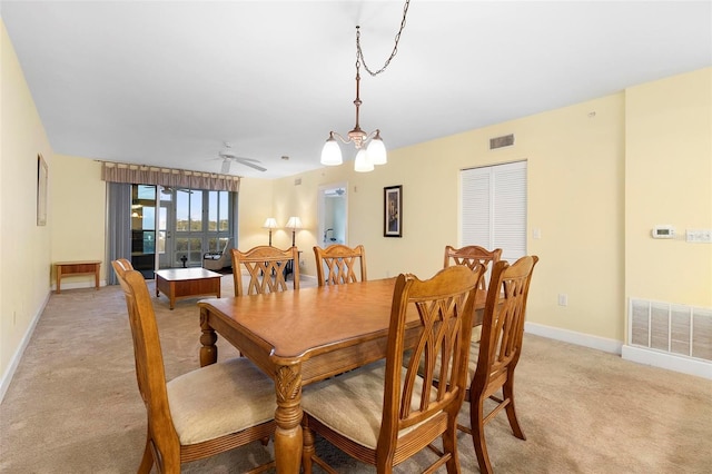 dining area with ceiling fan with notable chandelier and light carpet