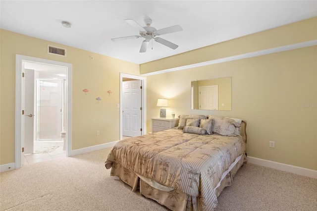 carpeted bedroom with ceiling fan and ensuite bath