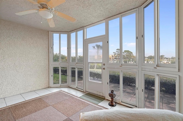 unfurnished sunroom with ceiling fan